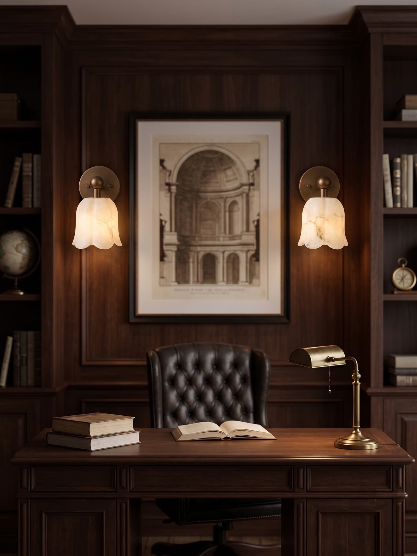 Pair of ruffled tulip-bell alabaster wall sconces flanking a framed architectural print in a dark wood-paneled study